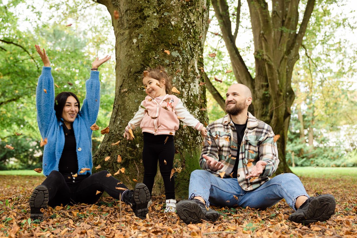 Ein fröhliches Familienfoto mit Eltern und Kindern, die zusammen lachen – aufgenommen in Heilbronn Fröhliches Familienfoto im Freien – lachende Familie Heilbronn