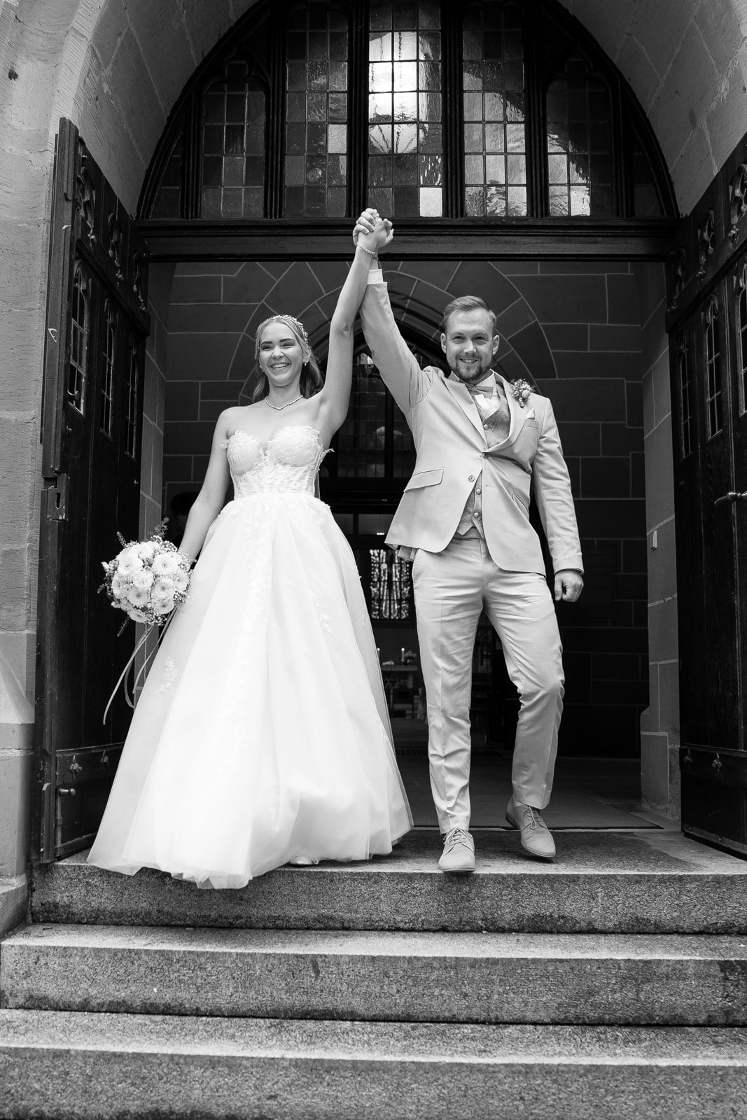 Hochzeitsfotograf Heilbronn Ludwigsburg begleitet Emotionaler Auszug des Brautpaars aus der Kirche – Romantische Hochzeitsreportage Frisch verheiratetes Brautpaar läuft Hand in Hand aus der Kirche. Hochzeitsfotograf Ludwigsburg und Heilbronn aufgenommenes Siegerbild.